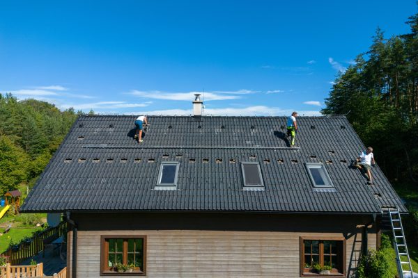 High angle view of men worker installing solar photovoltaic panels on a roof, alternative energy, saving resources and sustainable lifestyle concept.